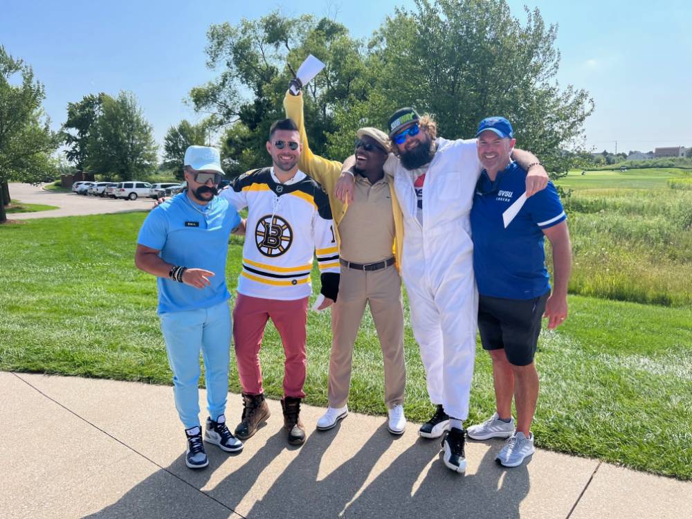 Five football alums having fun together on the course.